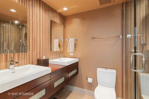 a bathroom with a double vanity sink toilet and shower