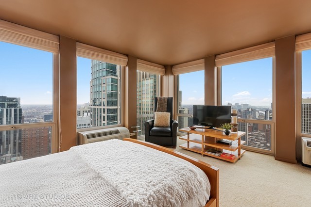 111 East Chestnut Street, Unit 43A Chicago, IL 60611 - Photo 5 of 16 a bedroom with a bed and large windows