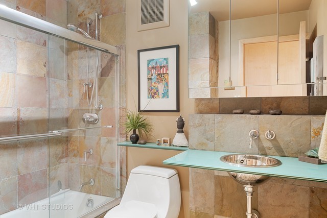 111 East Chestnut Street, Unit 43A Chicago, IL 60611 - Photo 6 of 16 a bathroom with a granite countertop sink a toilet a mirror and shower