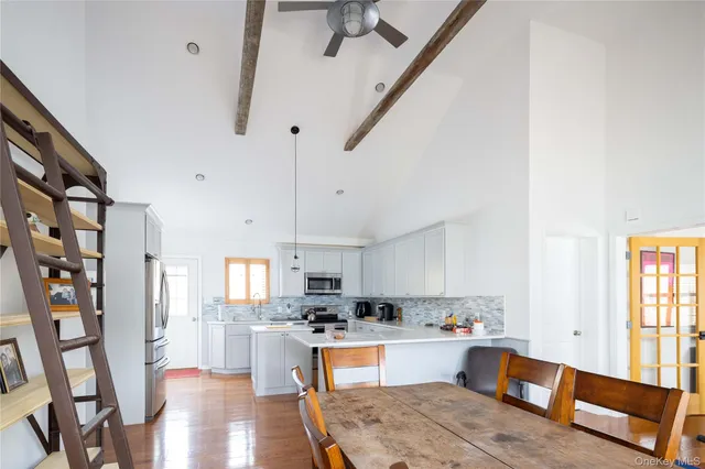 a kitchen with stainless steel appliances kitchen island wooden floors and view living room