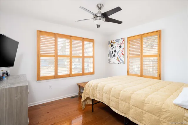 a bedroom with a bed tv and a window