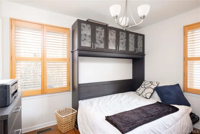 a bedroom with a bed window and a chandelier