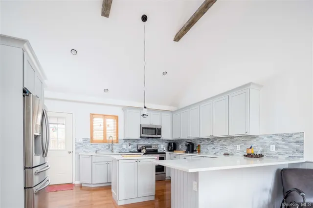 a kitchen with a sink a stove a refrigerator and white cabinets