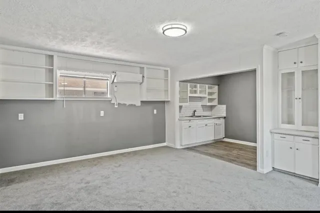 a view of a kitchen with white cabinets and wooden floor