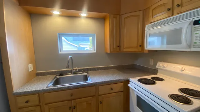 a kitchen with a sink a stove and cabinets