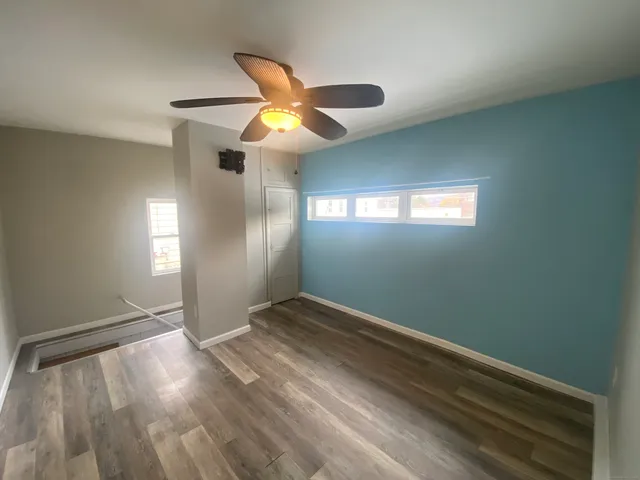 a view of empty room with window and ceiling fan
