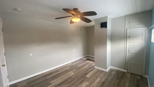 a view of an empty room with wooden floor