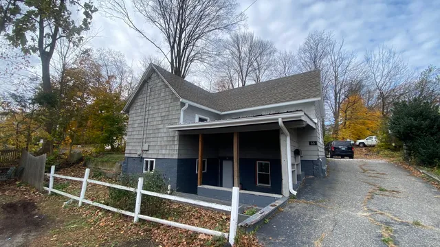 a view of a house with a large window and wooden fence