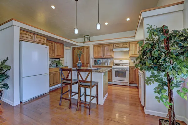 a kitchen with stainless steel appliances a refrigerator and a wooden floor