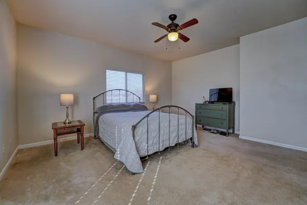 a spacious bedroom with a bed and a chandelier