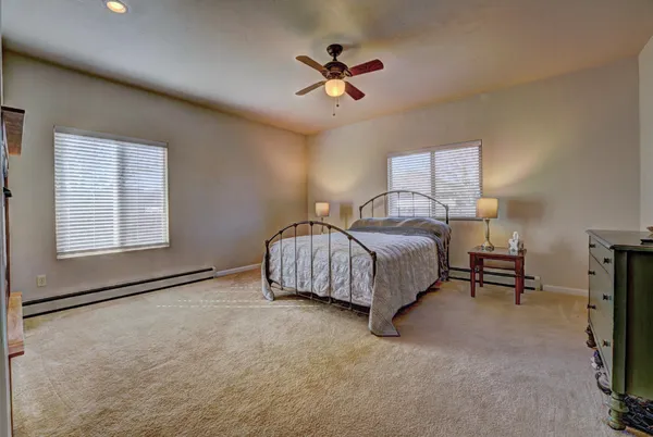 a spacious bedroom with a bed and a ceiling fan