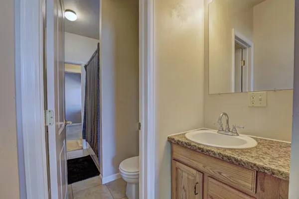 a bathroom with a sink a toilet and a mirror