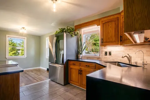 a kitchen with stainless steel appliances granite countertop a sink and a stove