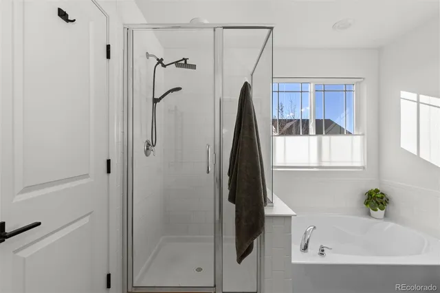 a bathroom with a tub shower and window