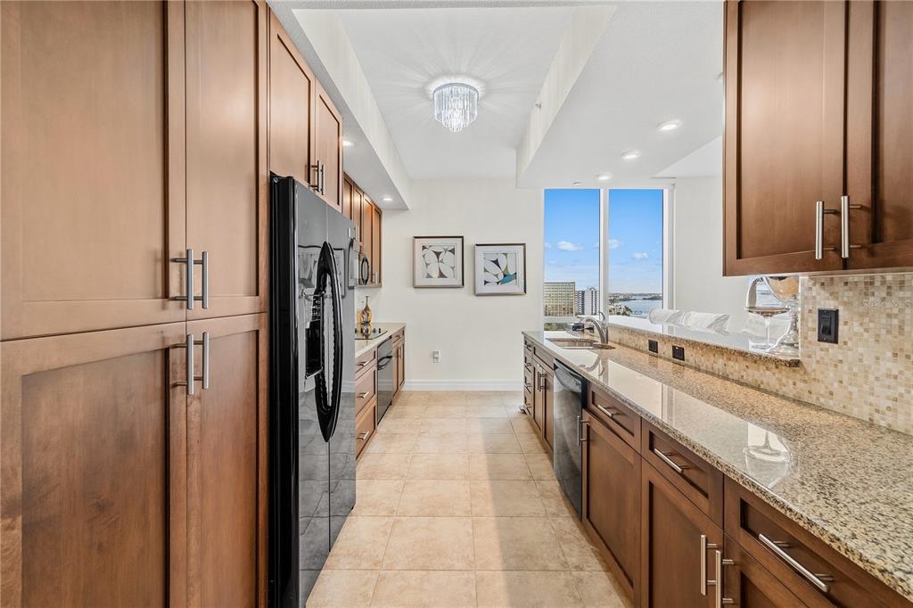 331 Cleveland Street, Unit 1103 Clearwater, FL 33755 - Photo 11 of 75 a large kitchen with stainless steel appliances granite countertop a refrigerator and a sink
