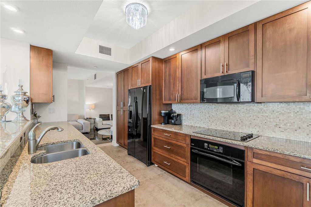 331 Cleveland Street, Unit 1103 Clearwater, FL 33755 - Photo 14 of 75 a kitchen with stainless steel appliances granite countertop a sink stove and refrigerator