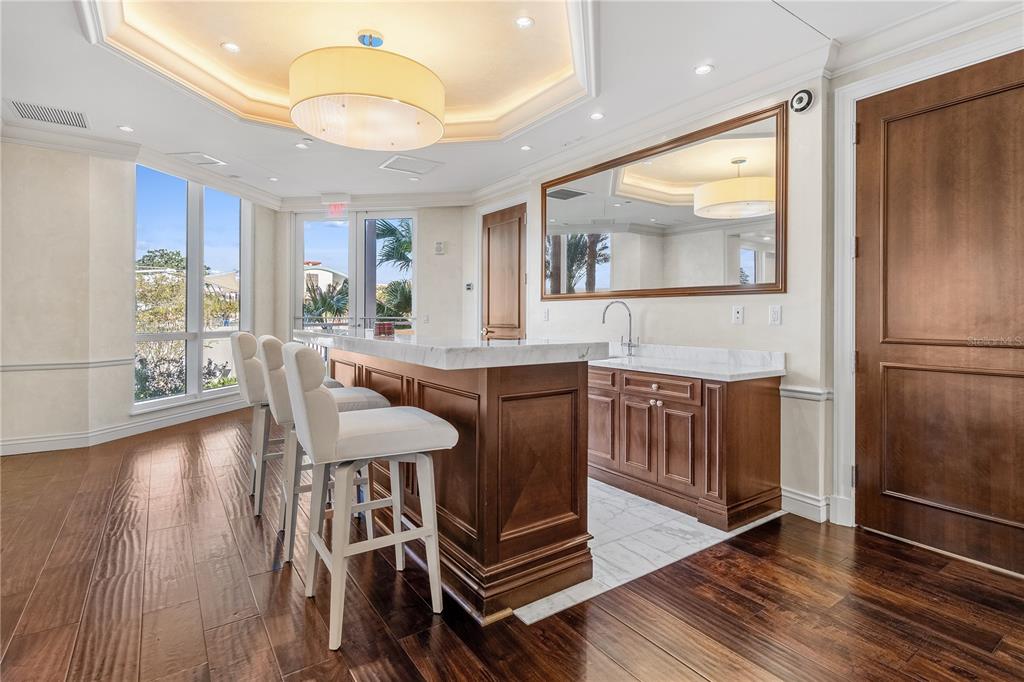 331 Cleveland Street, Unit 1103 Clearwater, FL 33755 - Photo 42 of 75 a kitchen with stainless steel appliances kitchen island granite countertop a table chairs and a refrigerator