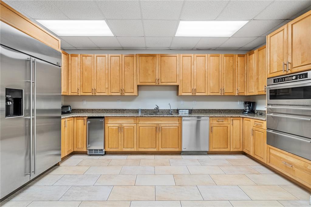 331 Cleveland Street, Unit 1103 Clearwater, FL 33755 - Photo 47 of 75 a kitchen with granite countertop a stove a sink and a refrigerator