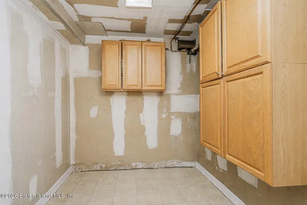a view of an empty room with chandelier fan