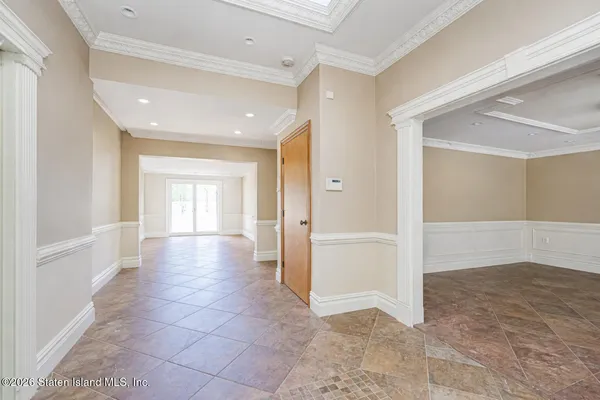 a view of a room with wooden floor chandelier and windows