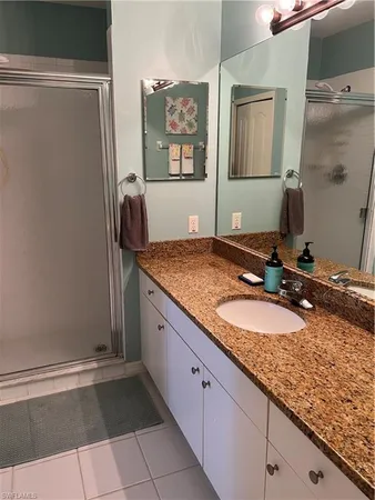 a bathroom with a granite countertop sink and a mirror