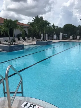 a view of swimming pool with outdoor seating and green space