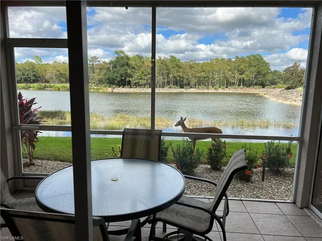 a view of a patio with a table chairs and a lake view