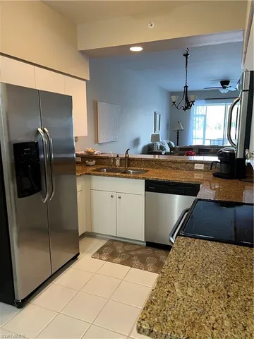 a kitchen with stainless steel appliances granite countertop a sink a stove a refrigerator and a cabinets