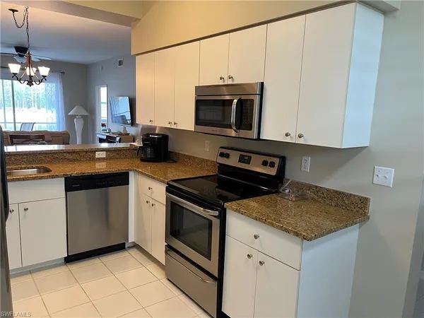 a kitchen with stainless steel appliances granite countertop a sink stove and microwave