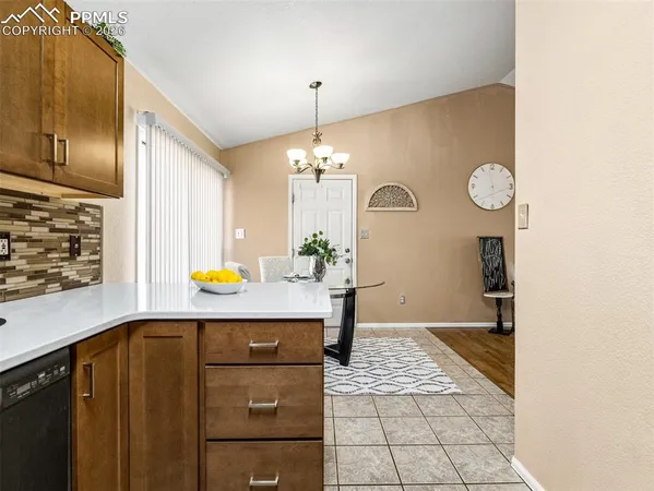 a view of kitchen with granite countertop cabinets and window