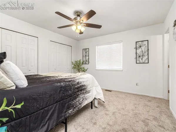 a spacious bedroom with a bed and a chandelier