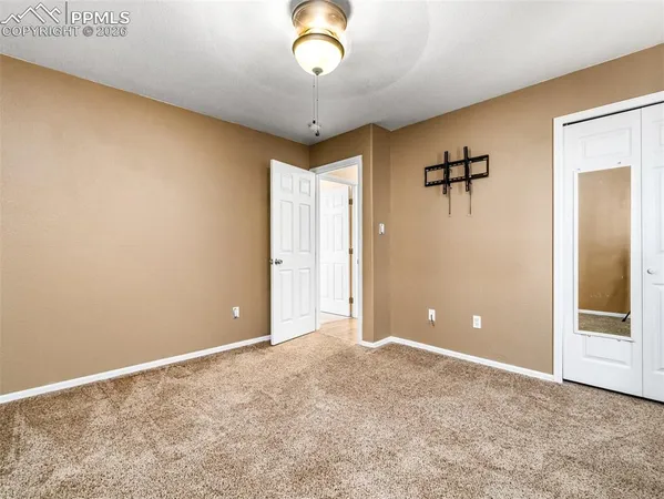 a view of a livingroom with a chandelier fan and closet
