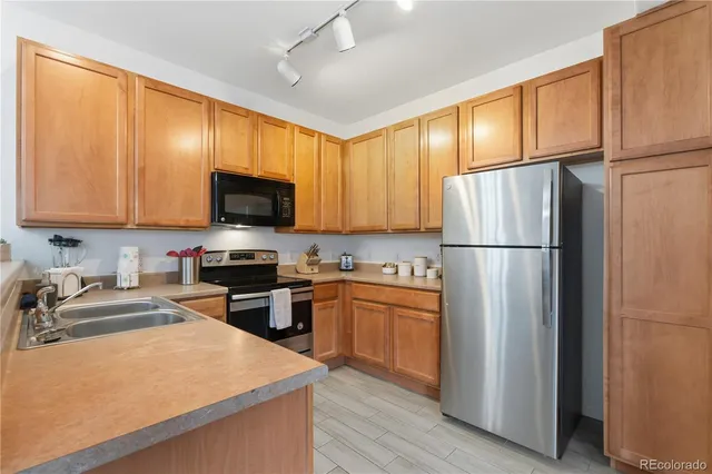 a kitchen with stainless steel appliances granite countertop a refrigerator stove microwave and sink
