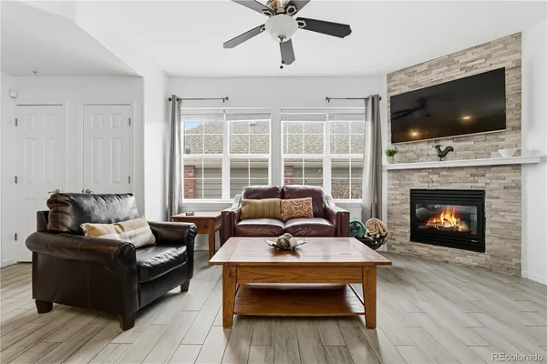 a living room with furniture a flat screen tv and a fireplace