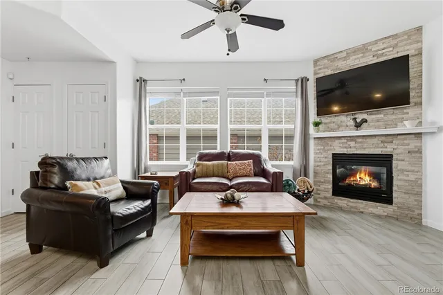 a living room with furniture a flat screen tv and a fireplace