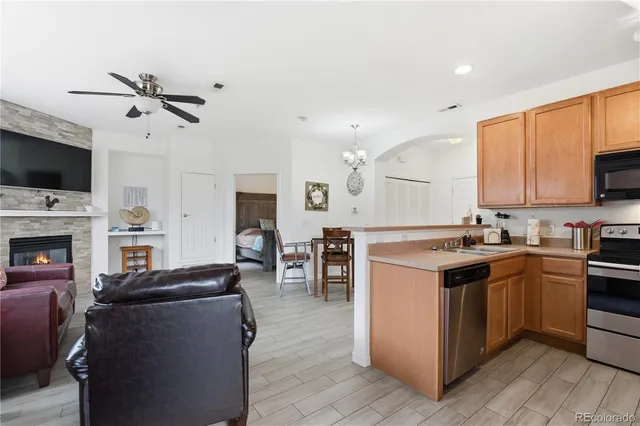a kitchen with a stove top oven a sink dishwasher and a refrigerator with wooden floor