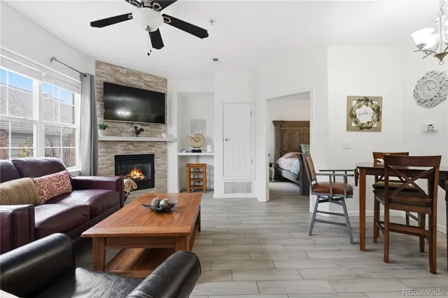 a living room with furniture a flat screen tv and a fireplace