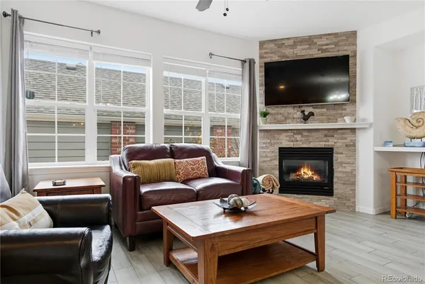 a living room with furniture a flat screen tv and a fireplace