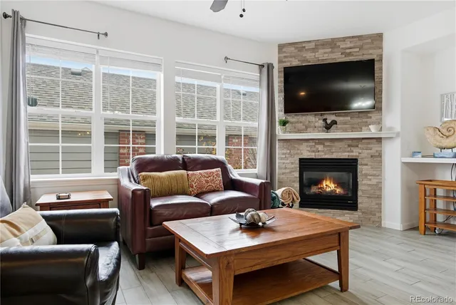 a living room with furniture a flat screen tv and a fireplace