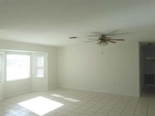 an empty room with windows and cabinet