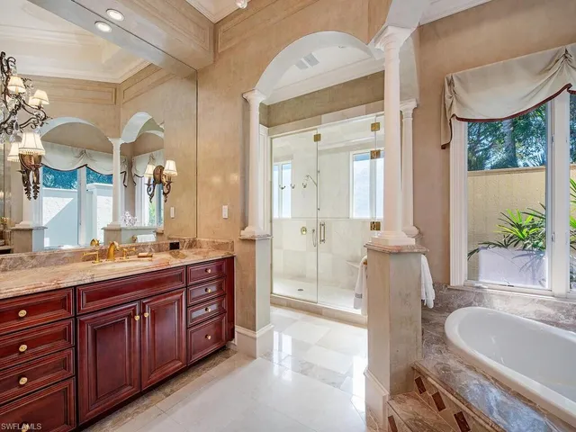 a spacious bathroom with a granite countertop sink mirror and a bathtub