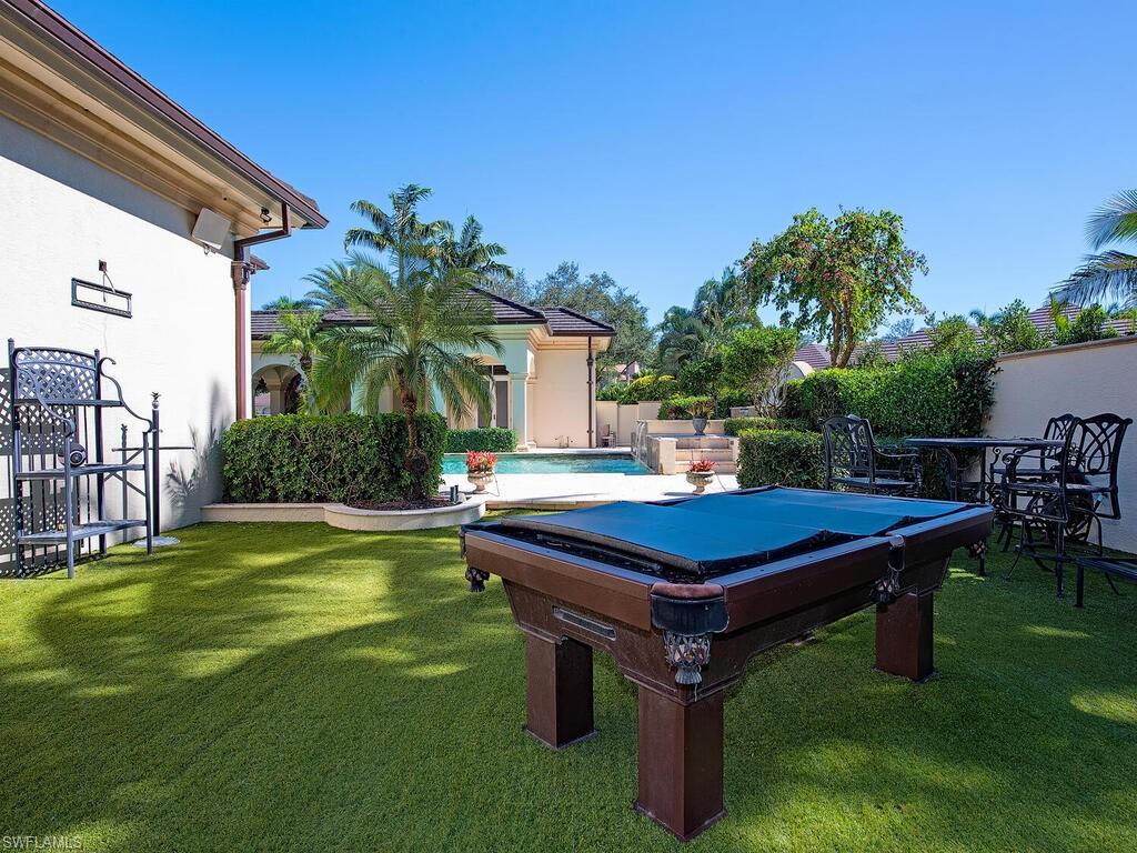 6955 Verde Way Naples, FL 34108 - Photo 40 of 42 a view of a backyard with swimming pool table and chairs