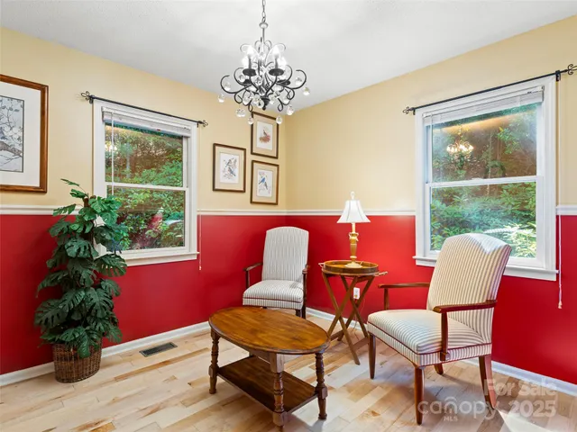 a view of a dining room with furniture a chandelier and wooden floor
