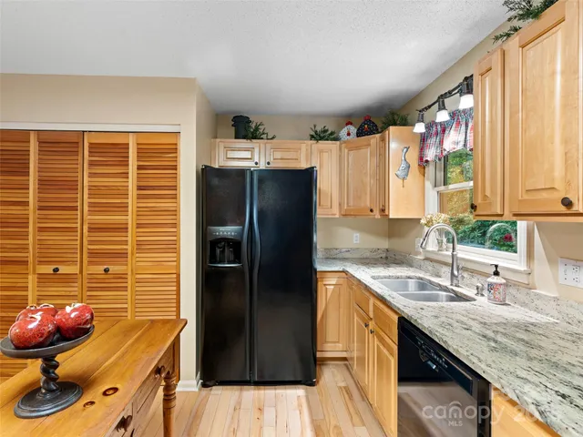 a kitchen with stainless steel appliances granite countertop a refrigerator and a sink