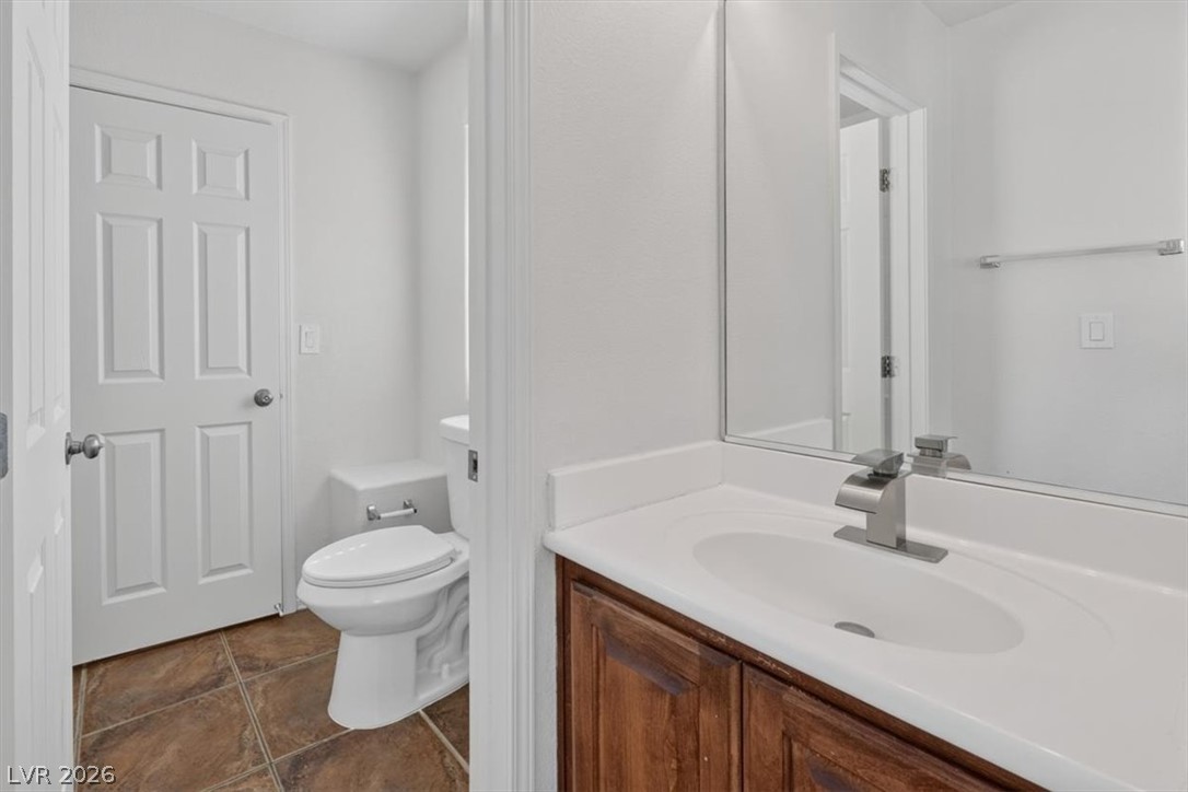 552 Albacate Street Henderson, NV 89015 - Photo 33 of 40 A compact bathroom with a vanity and a toilet, all on a tiled floor.