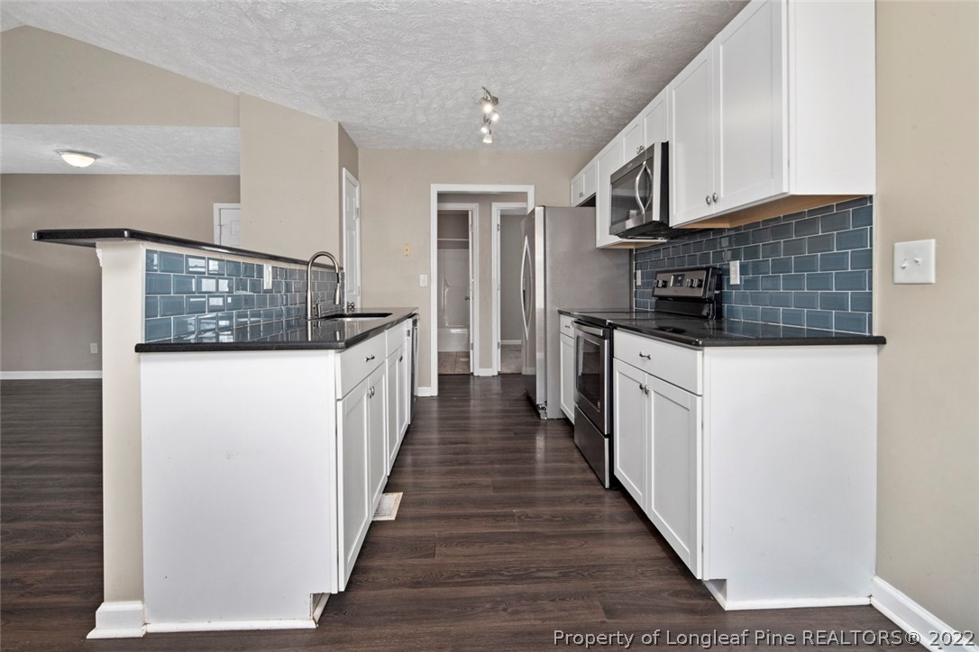 6573 Applewhite Road Fayetteville, NC 28304 - Photo 13 of 35 a kitchen with stainless steel appliances granite countertop a refrigerator and a stove top oven