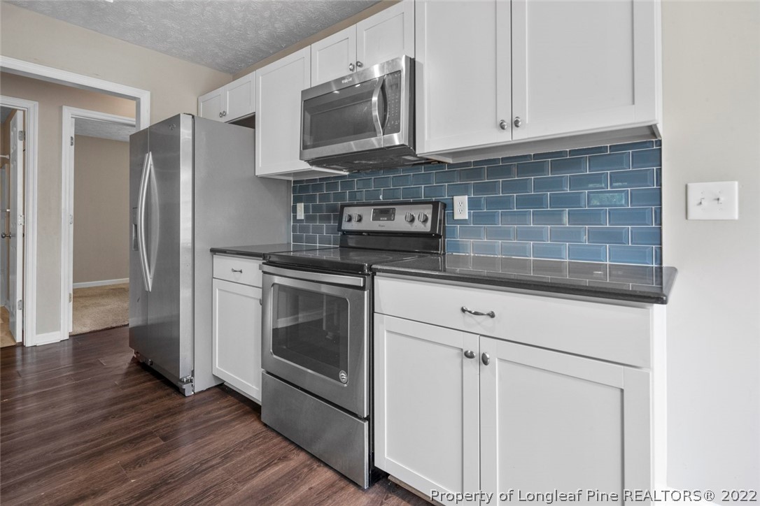 6573 Applewhite Road Fayetteville, NC 28304 - Photo 16 of 35 a kitchen with stainless steel appliances granite countertop a stove a microwave and a refrigerator