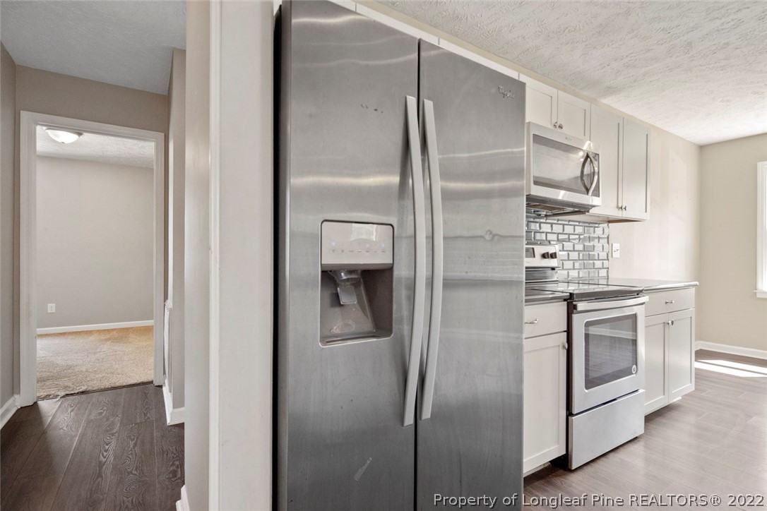 6573 Applewhite Road Fayetteville, NC 28304 - Photo 18 of 35 a kitchen with stainless steel appliances granite countertop a refrigerator and a stove