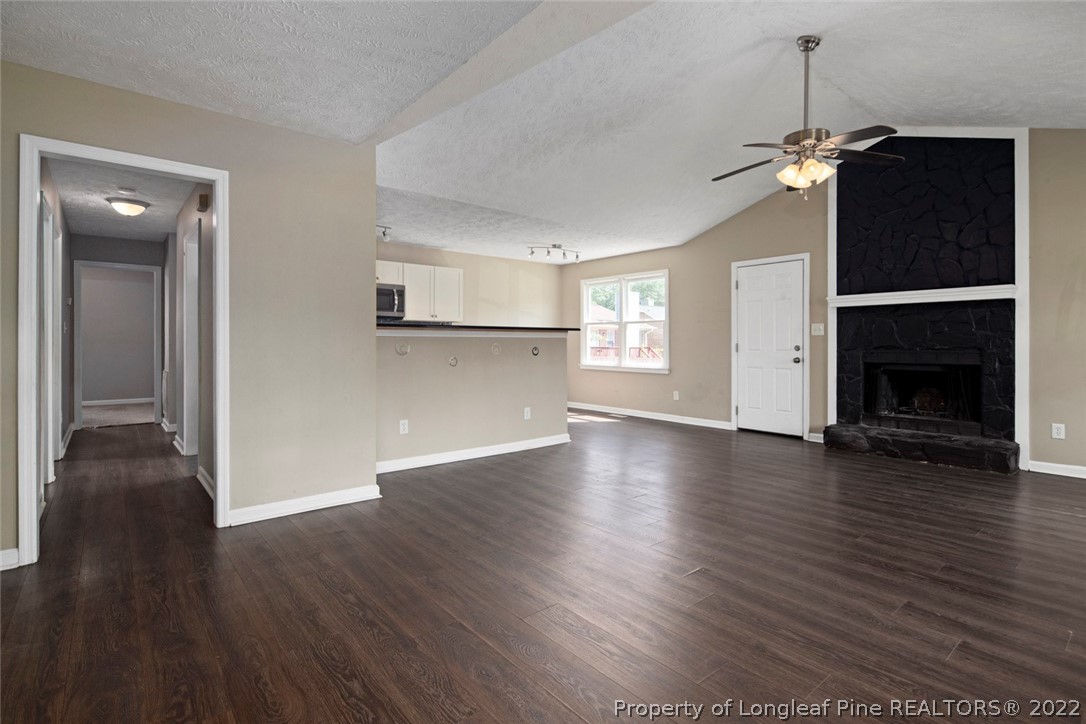 6573 Applewhite Road Fayetteville, NC 28304 - Photo 7 of 35 a view of a livingroom with wooden floor a ceiling fan and windows