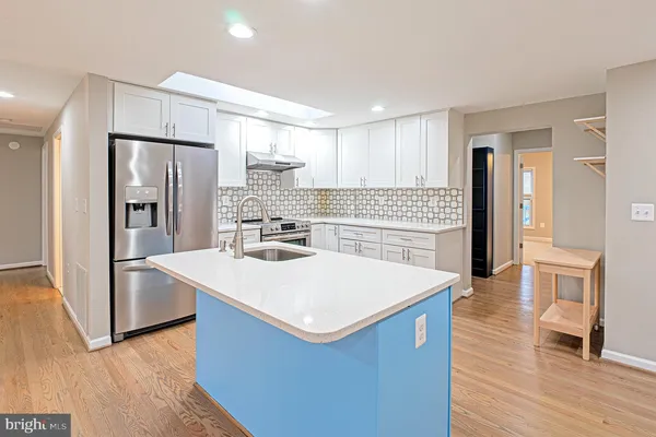 a kitchen with stainless steel appliances a refrigerator and wooden floor
